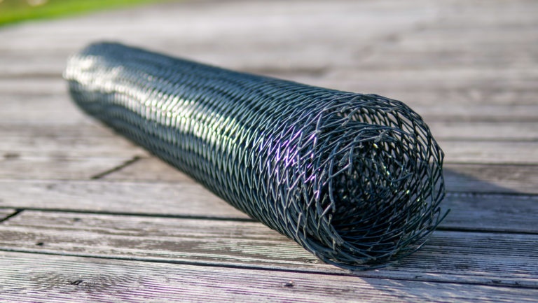 Srolované zelené ochranné pletivo Polynet položené na dřevěné podlaze